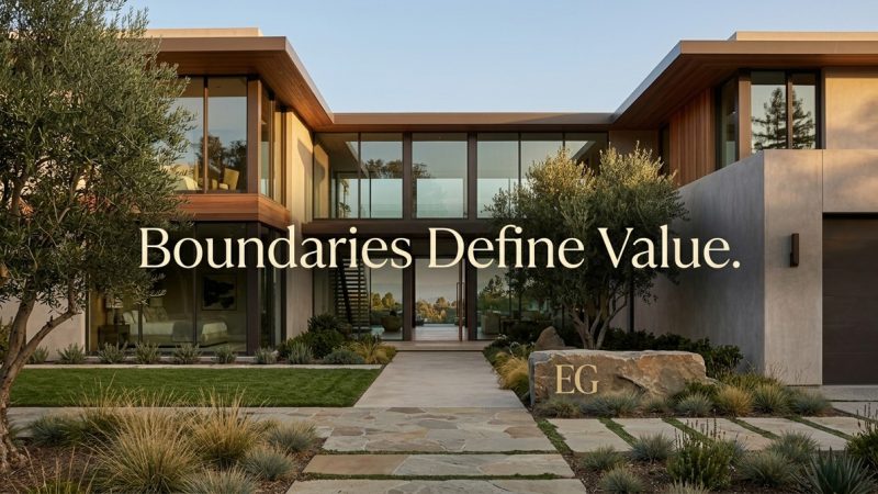 Modern luxury home with glass walls, olive trees, and a stone path. Text: "Boundaries Define Value.
