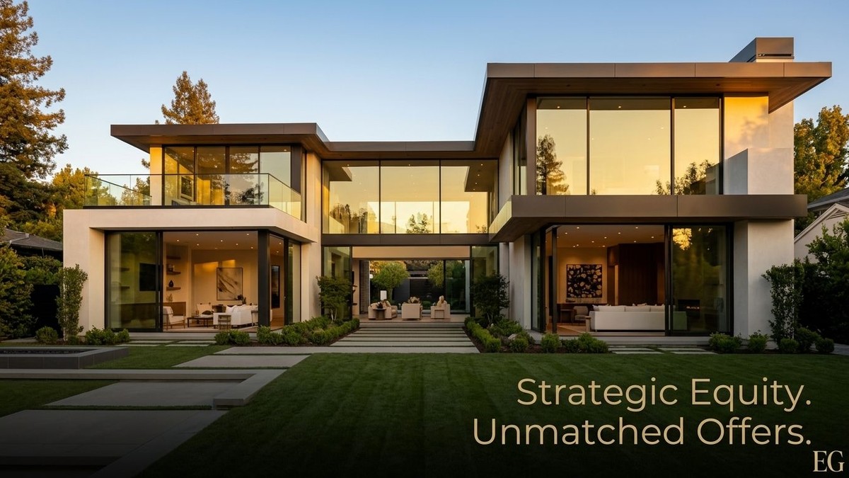 Modern luxury home with large glass windows reflecting golden light, green lawn, and trees at sunset.
